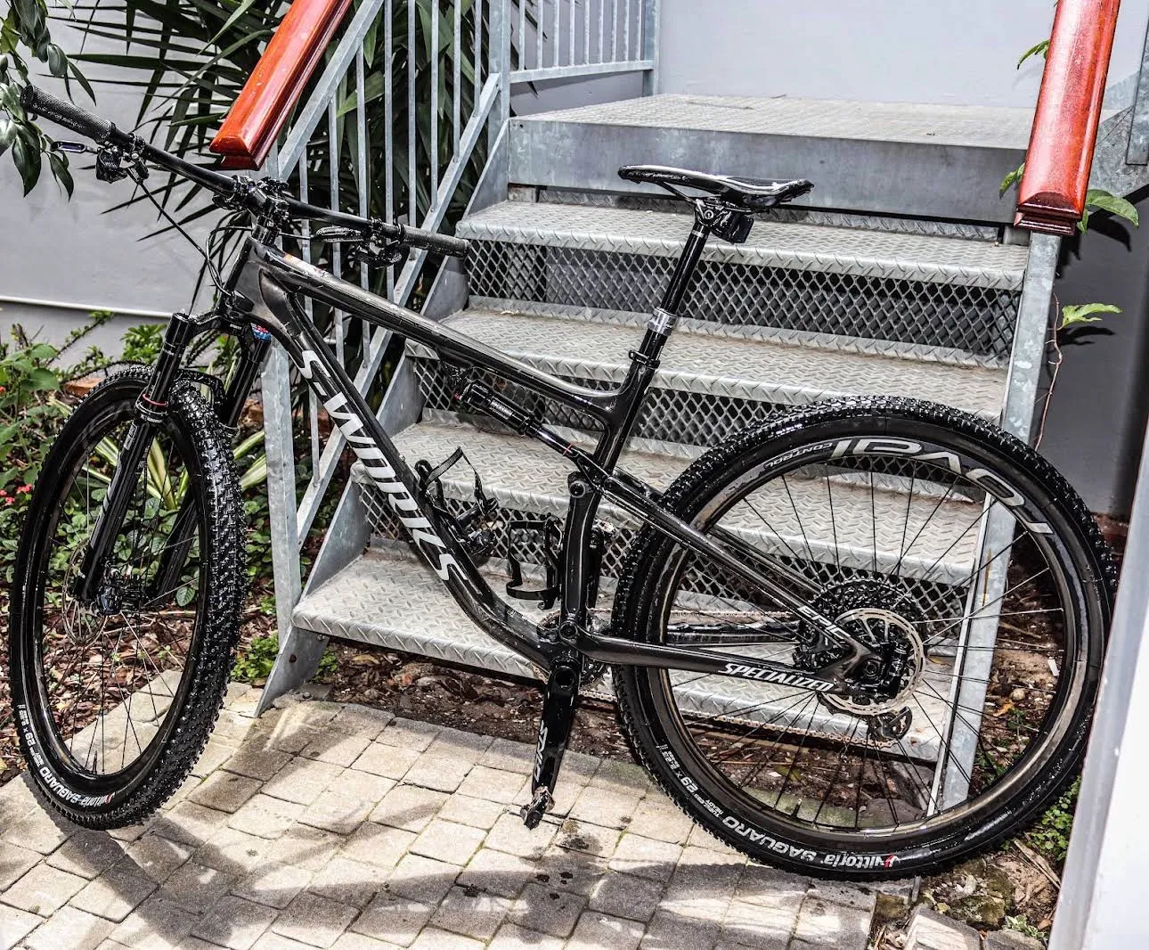 A full-suspension mountain bike photographed outside the shop.