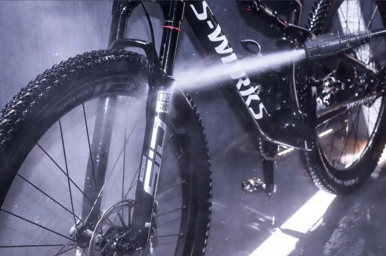 A mountain bike fork being rinsed down in the wash bay.
